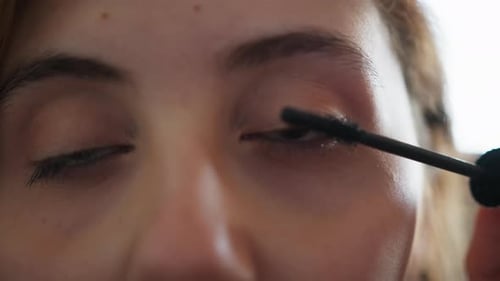 Woman Applying Mascara in Close Up Beauty Shot