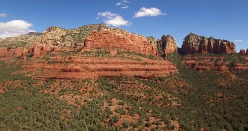 Aerial pull back to reveal multiple red rock formations, Sedona, Arizona.