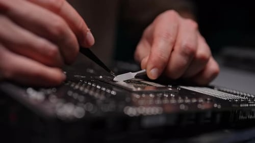 Computer Technician Meticulously Cleaning Off Leftover Thermal Paste From CPU Socket on Computer
