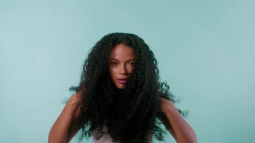 Happy Young Woman Tossing Curly Hair
