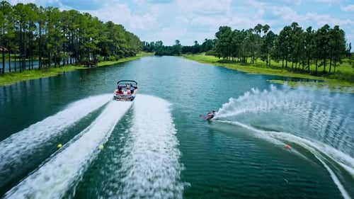 Aerial Drone View of Waterskier Speeding on Resort Lake.
Following Shot of Professional Female Skier
