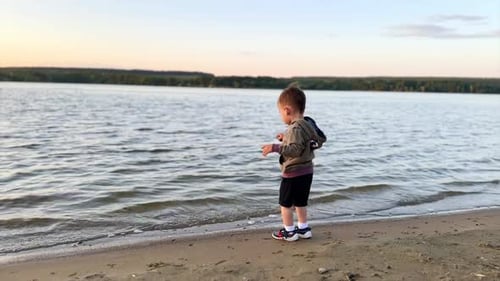 Young Child Playing on Beach at Sunset