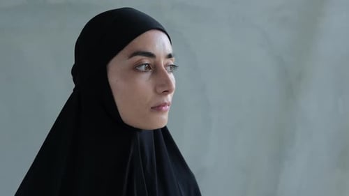 Woman in Black Head Covering Looks off to Side