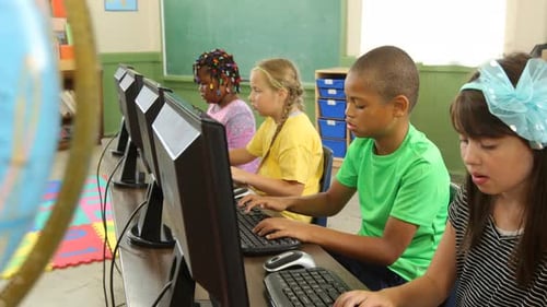 Diverse students smiling and learning together in a school computer class