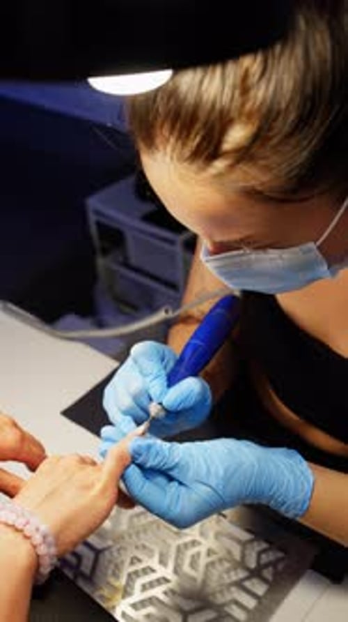 Woman Uses Electric File on Nails at Salon