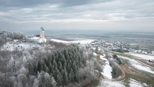 Scenic Aerial View of a Snowy Village and Historic Church