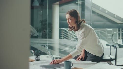 Young Female Architect Is Hard at Work in Her Office on Blueprints and Projects