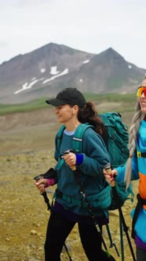 Woman Trekking with Backpack and Hiking Poles Along Rugged Mountain Trail Enjoying Outdoor Adventure