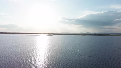 Black Sea with Cool Water Extends Beyond the Horizon Under a Sky with Clouds and a Dawn Sun