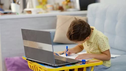 Young Boy Drawing Indoors at Home on Couch