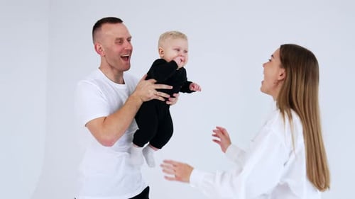Happy Family Posing with Baby in White Studio
