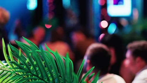Blurred Crowd in a Nightclub with Palm Fronds
