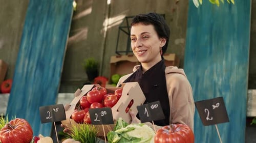 Smiling Woman Holding Fresh Tomatoes at Farm Stand