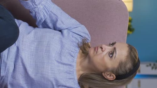 Vertical video of Paranoid woman looking around at home.