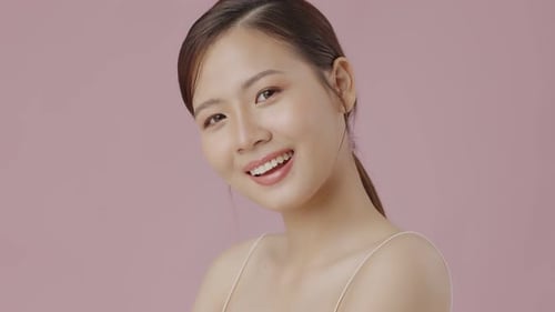 Smiling Brunette Woman Posing Against Pink Background