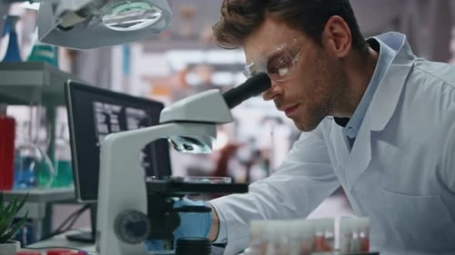 Genetik-Experte schaut unter das Mikroskop und untersucht aus nächster Nähe im Labor