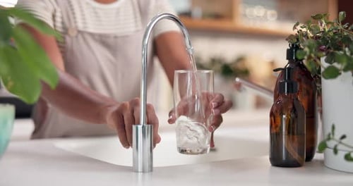 Water Faucet Filling Glass in Bright Kitchen