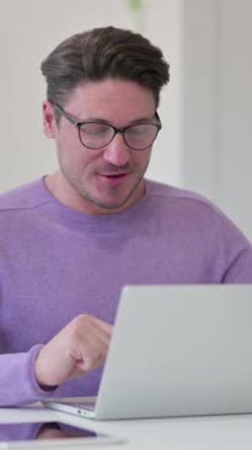 Video Chat on Laptop by Middle Aged Man in Office, Vertical Video