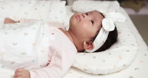 Baby Lying on Bed Looking Upward