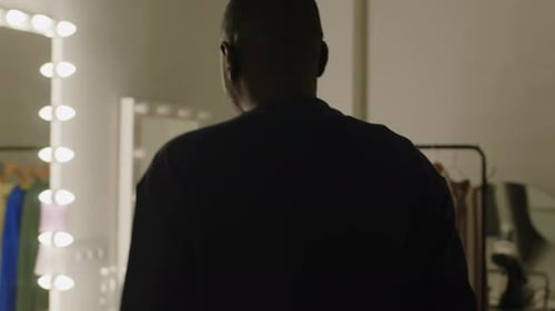 Man Prepares at a Makeup Table