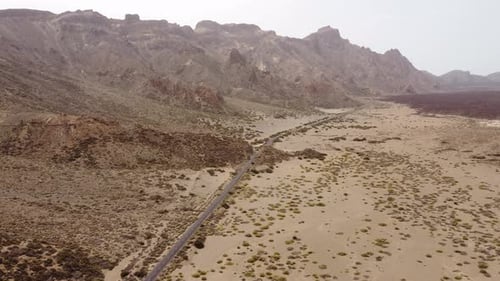 Aerial desert road through volcanic mountain landscape