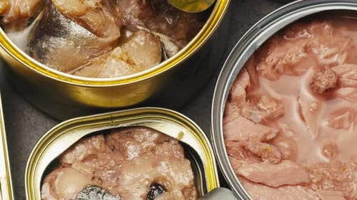 Opening Metal Cans with Canned Fish and Pate on Table Top View Canned Salmon and Tuna Macro Canning