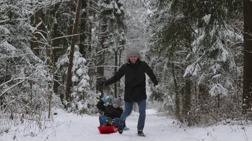 Family Having Fun in Winter Snowy Forest