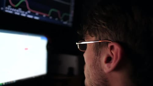 Young Financial Analyst Working on Computer with Multimonitor Stock Market Broker Analysing Graphs