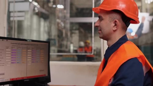 Man Works at Computer in Modern Factory