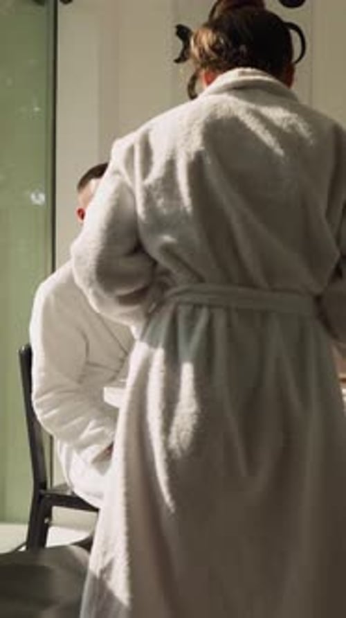 Couple Enjoying Tea Indoors Wearing Bathrobes