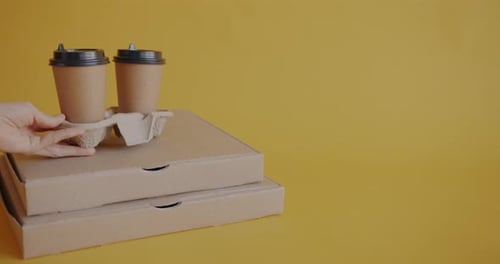 Pizza Boxes and Two Coffee Cups on Yellow