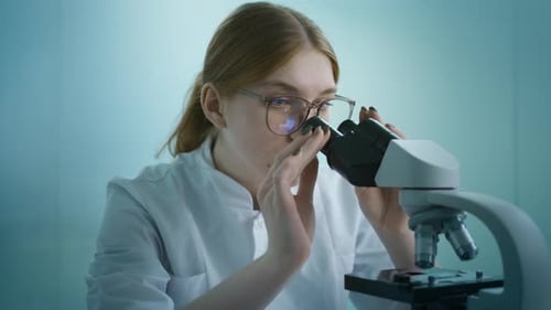 Young Scientist Uses Microscope in Medical Lab