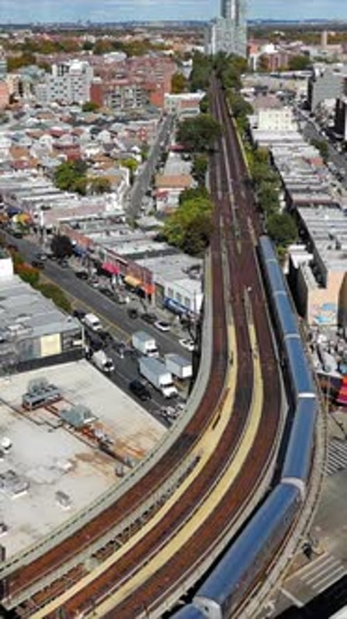 Aerial View of Urban Train Tracks and Cityscape Elevated Train Tracks Curve Through a Bustling Urban