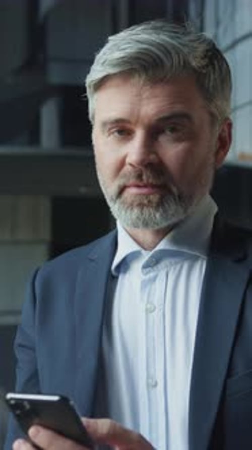 Footage of Handsome Smart Caucasian Businessman Holding Smartphone in Hands Reading Message Portrait