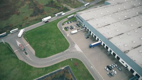 Buildings of logistics center, warehouses near the highway, view from height, a large number of truc