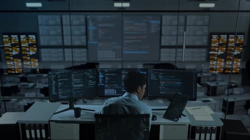 Asian Man Working With Tablet While Write Code With Multiple Computer Screens In office