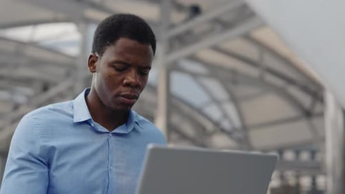 African American Handsome Man Businessman Guy Freelancer in the City Working Online with a Laptop