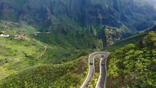 Cars Driving Through Sharp Turn on Winding Zig Zag Serpentine Road in Mountains
