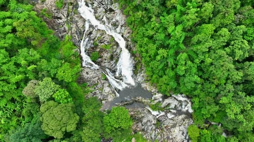 Drone captures stunning tropical waterfall.