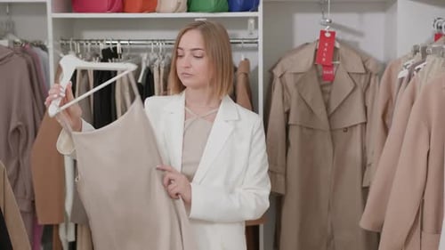 Uma mulher experimenta um vestido de seda marfim com alças