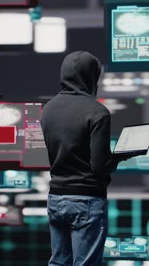 Man with Laptop in Front of Screens