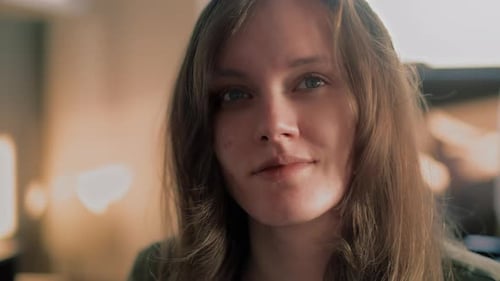 Cinematic close up of a Young White Woman smiling straight into the camera during a golden hour Sunr