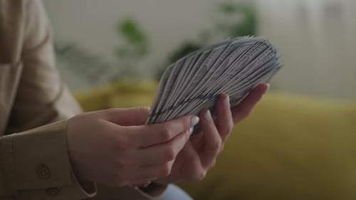 Woman Holding Stack of Money Indoors Close-Up
