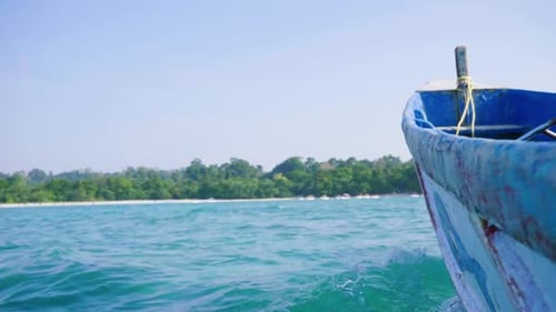The view toward shore from an old fishing boat with a motor with tourist boats in the distance white