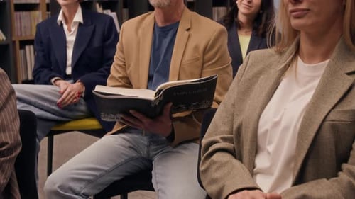 Group of People Laughing While Listening to Speaker During Book Club in Library