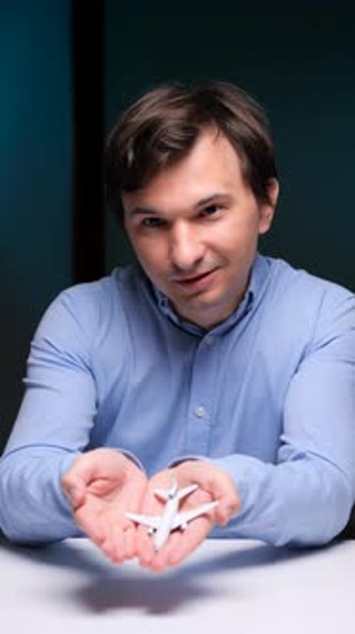 Man Holds Small White Airplane Model