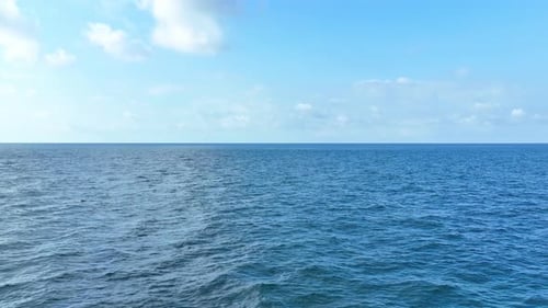 Drone flying the blue sea and wave, blue sky and white clouds. 4K.