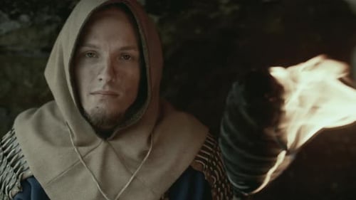 Portrait of Medieval Man Holding Torch Inside Dark Fortress Tunnel
