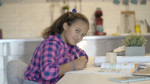 Girl Studies at Kitchen Table in Daytime