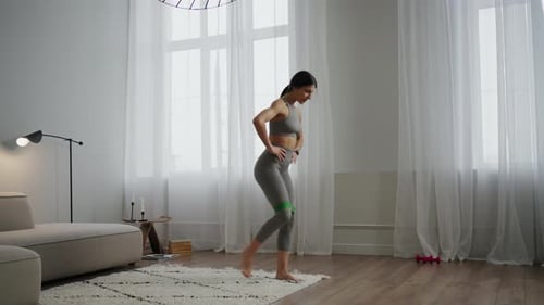 Woman Doing Lunge Exercise with Resistance Band at Home